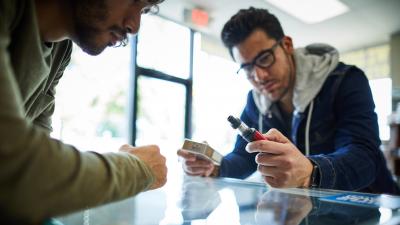 Man in a store looking at an e-cigarette