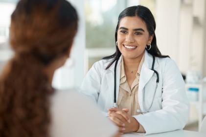 Young doctor sitting with her patient during a consultation