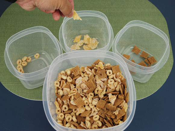 Cereal in big bowl being separated back into their original bowls