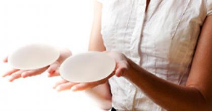 Photo of a woman holding silicone breast implants in her hand