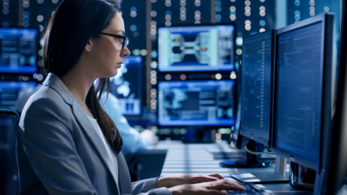 Employee typing while staring at a computer screen.