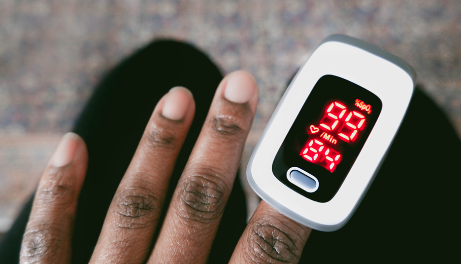 A pulse oximeter on a person's finger.