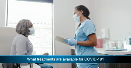 Older female patient speaking with doctor about COVID-19 treatment in hospital room.