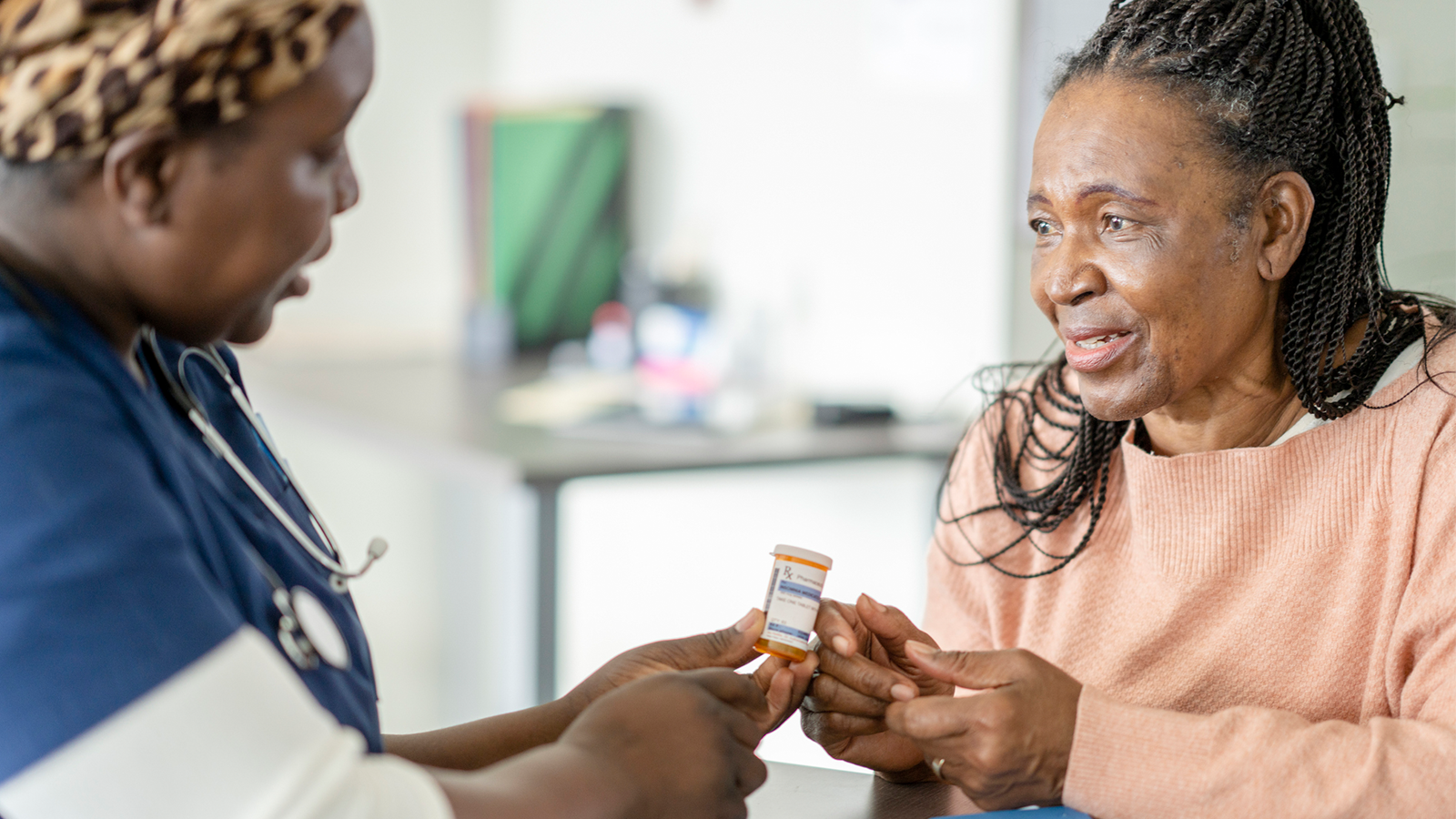 elderly woman speaking to a pharmacist about pharmaceutical quality.