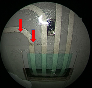 Endoscopic view with red arrows pointing to evidence of water intrusion