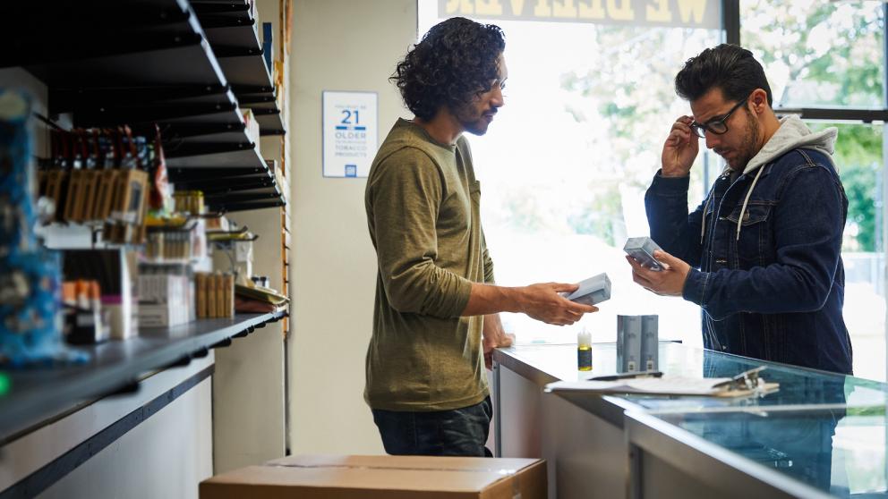 man in retail vape store talking with customer