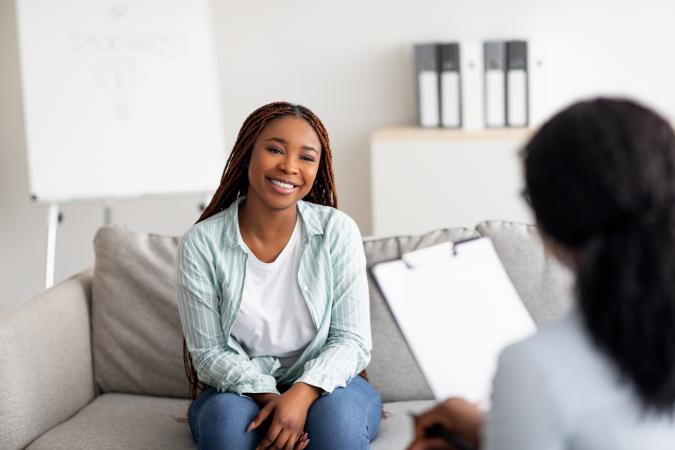 Young female client having consultation with psychologist
