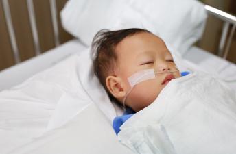 Baby in hospital bed with canula 