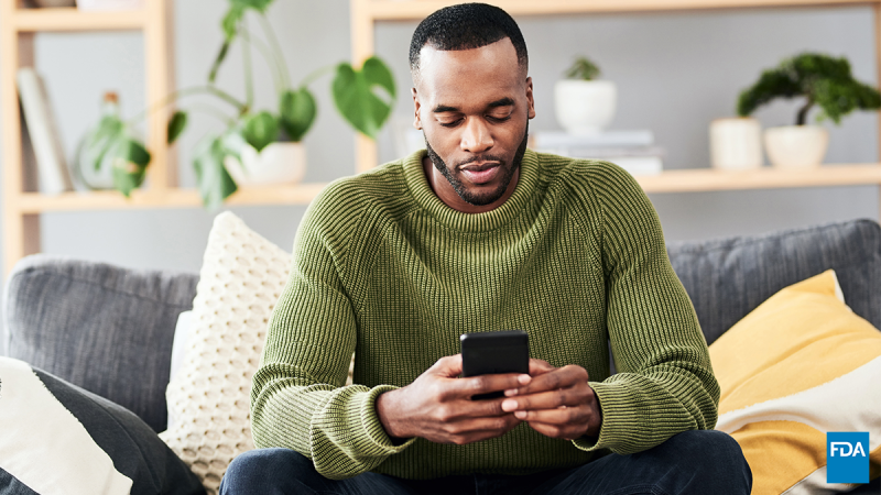 Man using cell phone while sitting on a couch