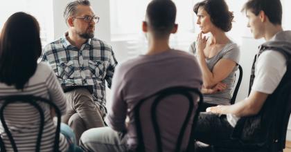 5 adults speaking in a circle