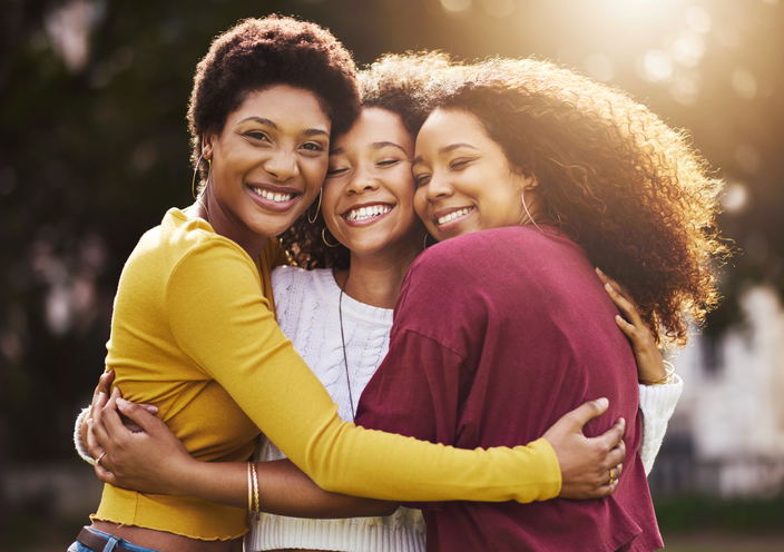 Three African American woman hugging. 