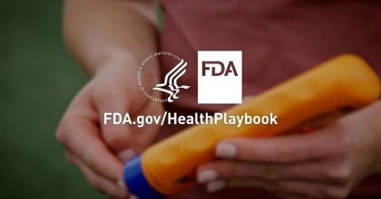 Close-up image of a person squeezing a sunscreen bottle. There is a text overlay with the text reading FDA dot gov forward slash Health Playbook.