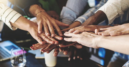 Multiracial group of people joining hands in stack