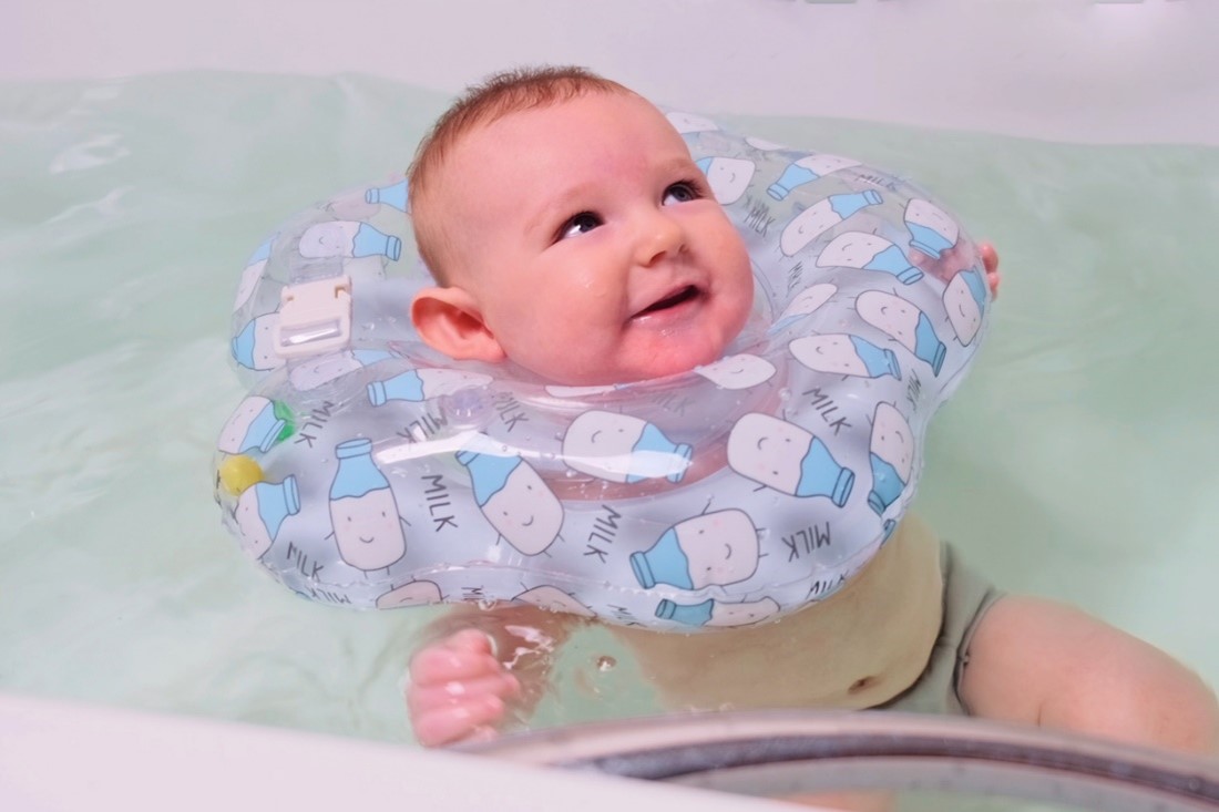 Image of a baby in water with a neck float