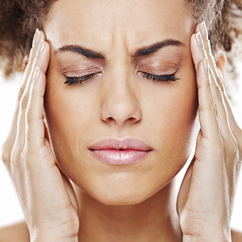 woman with headache rubbing temples (350x350)