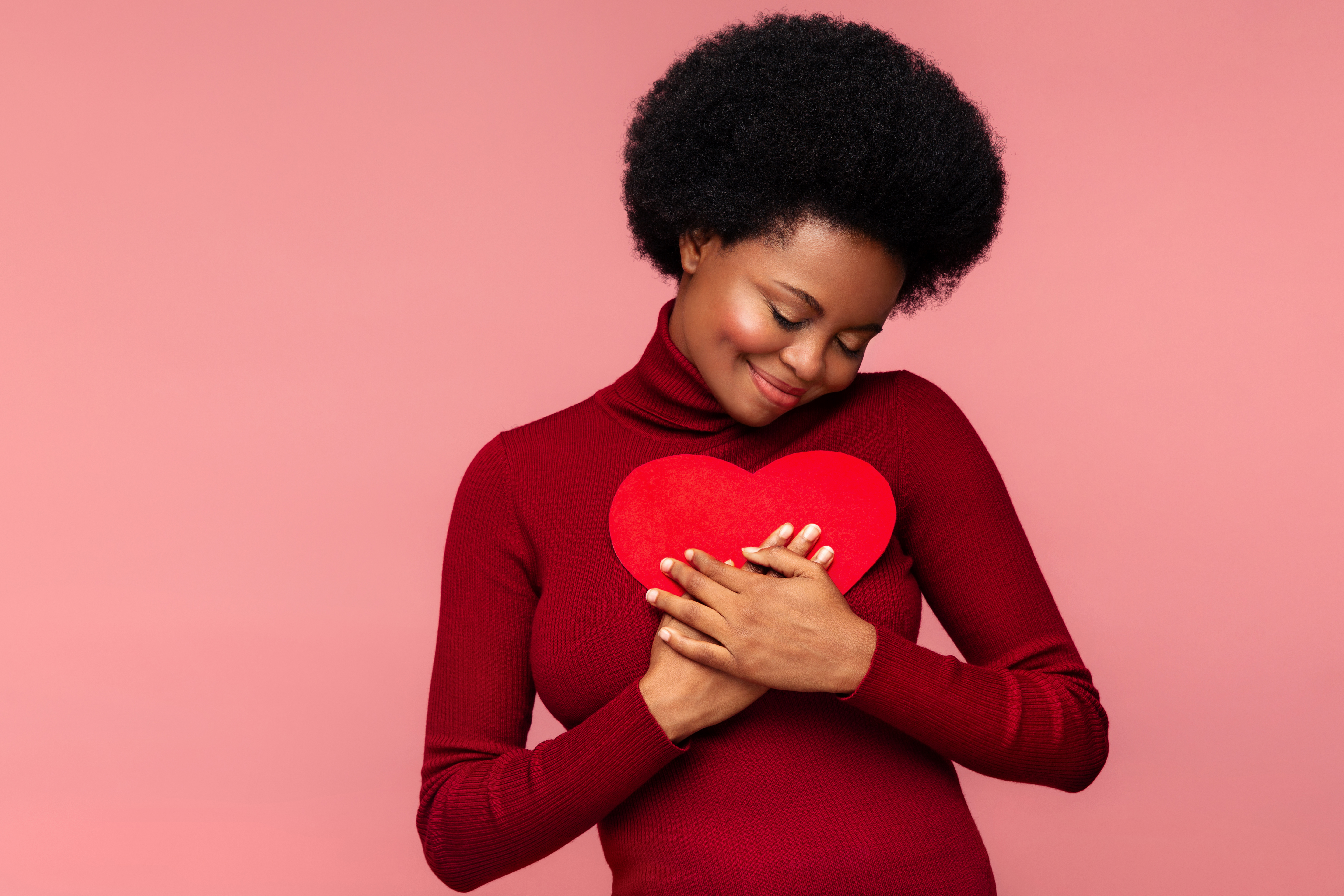 Young woman hugging a paper stock heart