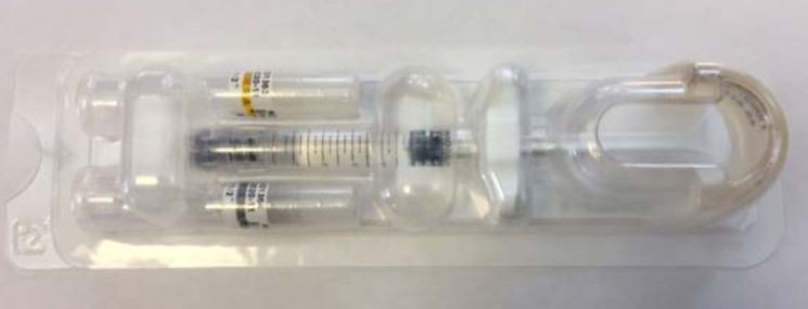 Filled syringe in a blister pack unit with two sterile needles and two patient record labels.