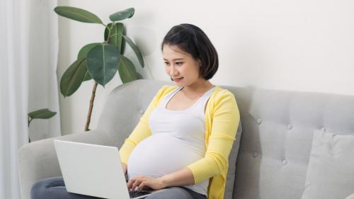 Image of pregnant Asian woman working on a laptop