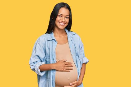 Pregnant young woman cradling her stomach