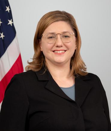 Headshot of Suzanne Roosen with flag