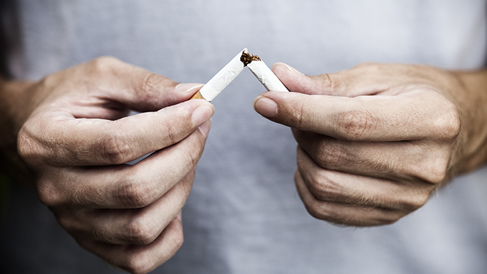 person breaking a cigarette in half