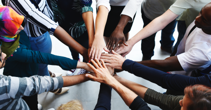 Group of people with hands in the middle