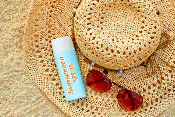 SPF 15 Broad Spectrum Sunscreen, Sunglasses and Broad Brimmed Hat on Beach (600x400)