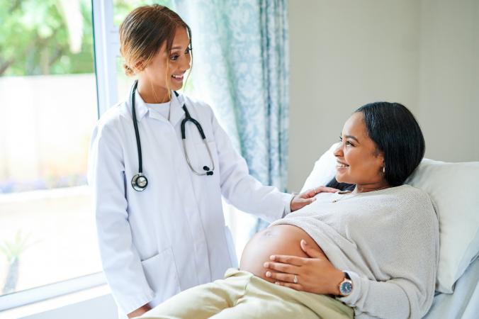 Young doctor checking pregnant woman at hospital