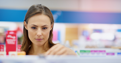 Female customer at a pharmacy looking at different over the counter medicines.