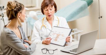 Female doctor meeting with female patient and pointing to a gynecological diagram. Making Laparoscopic Power Morcellators Safer.​