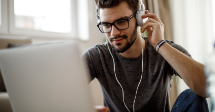 Man wearing headphones sitting at laptop