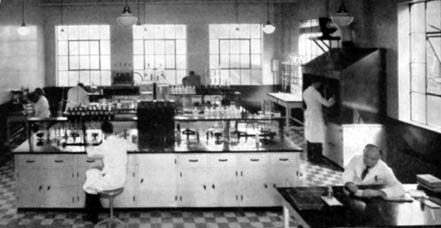 Several people in white lab coats working in a laboratory